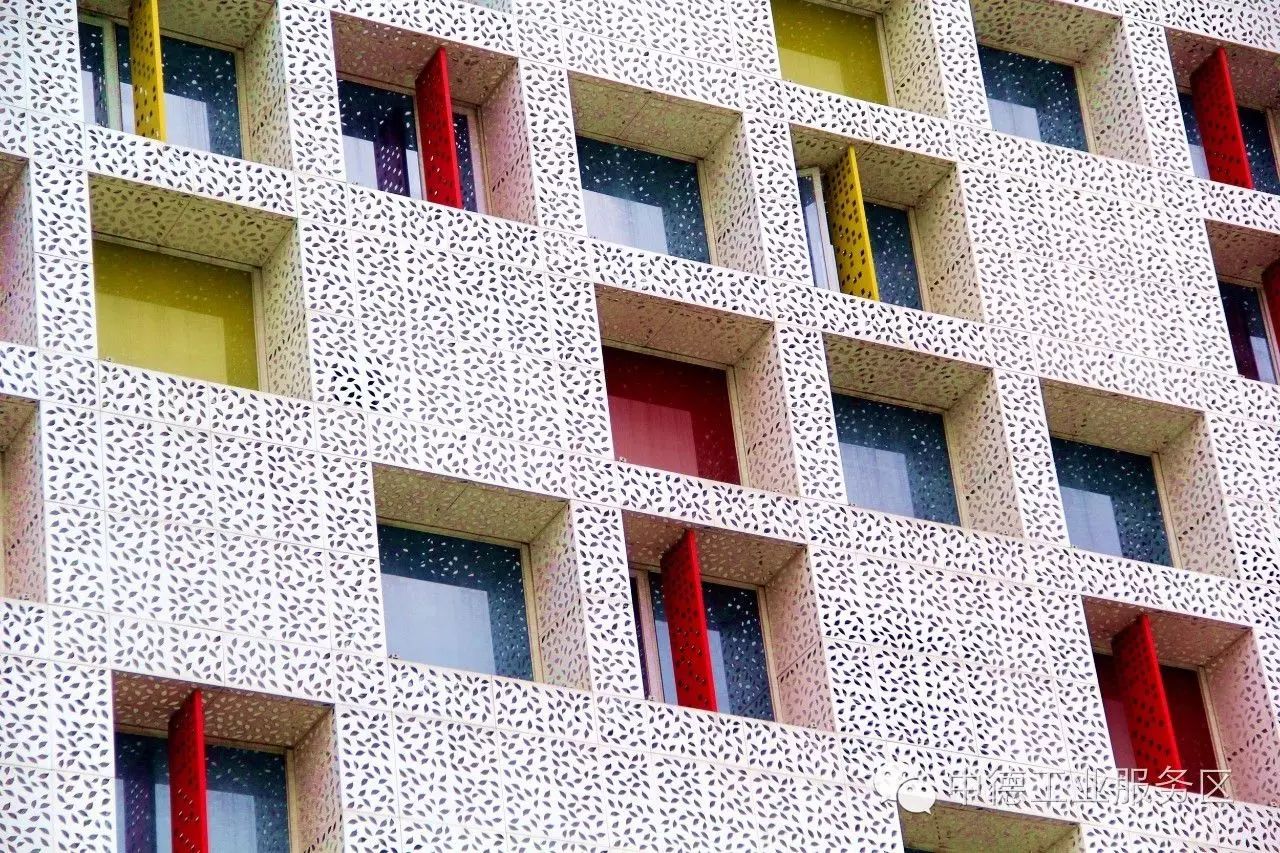 佛山剪纸装饰的外墙            镂空的白色金属穿孔板,黄红相间的