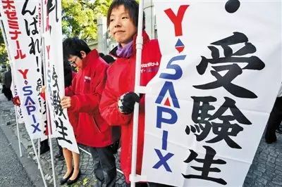 路边给高考生加油的补习班工作人员