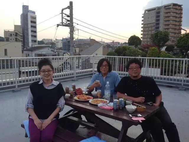 本文作者(中)与日本作家友人夫妇在俯瞰“叮叮电车”的阳台上小酌
