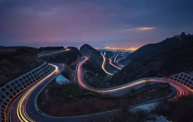 璀璨夜景 夜幕降临,但见远处五彩斑斓,灯光点点,近处蜿蜒曲折的公路上