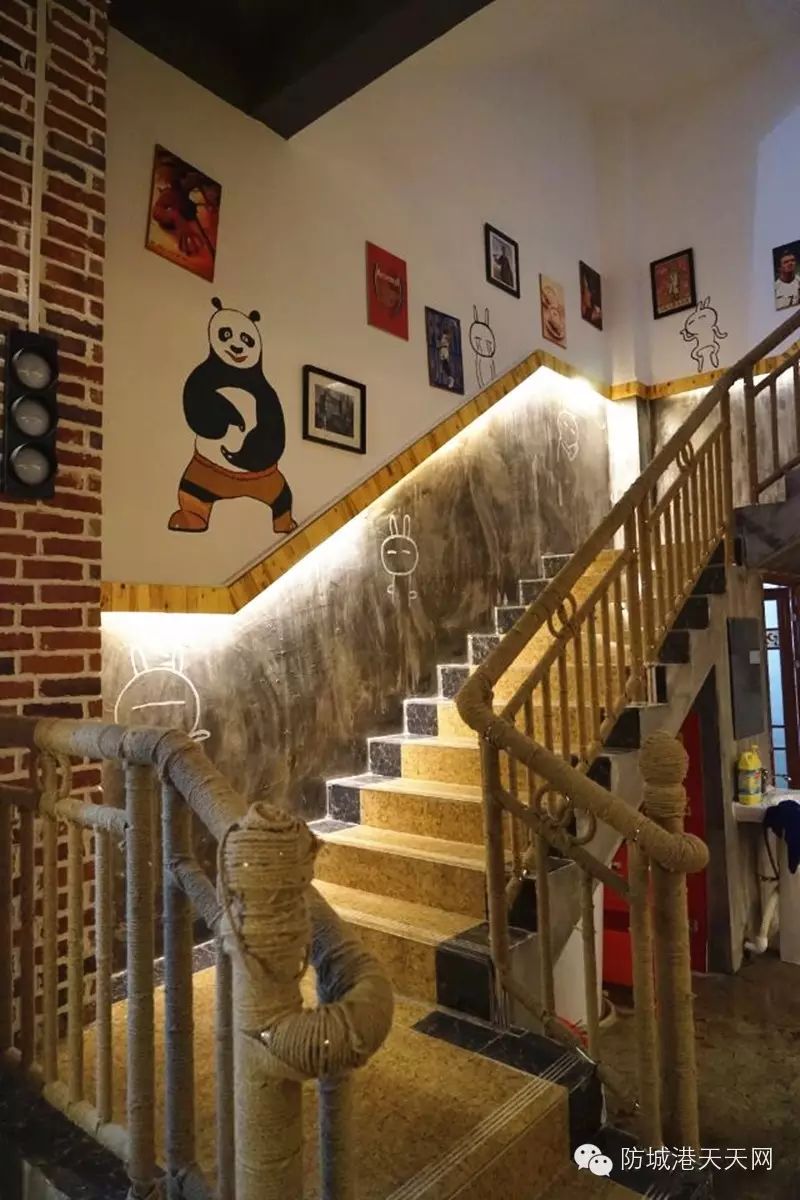 通往二楼的楼梯,麻绳缠绕的楼梯扶手,搭配墙面上的功夫熊猫和各个