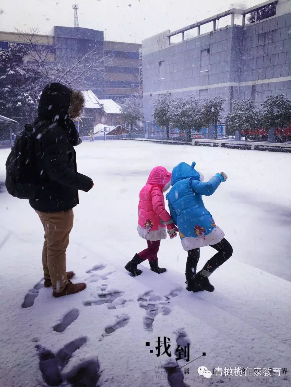 父女在雪地里踩脚印,画出一颗心来.