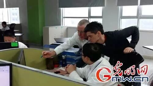 图为某企业设计人员在讨论方案（光明网记者刘超/摄）