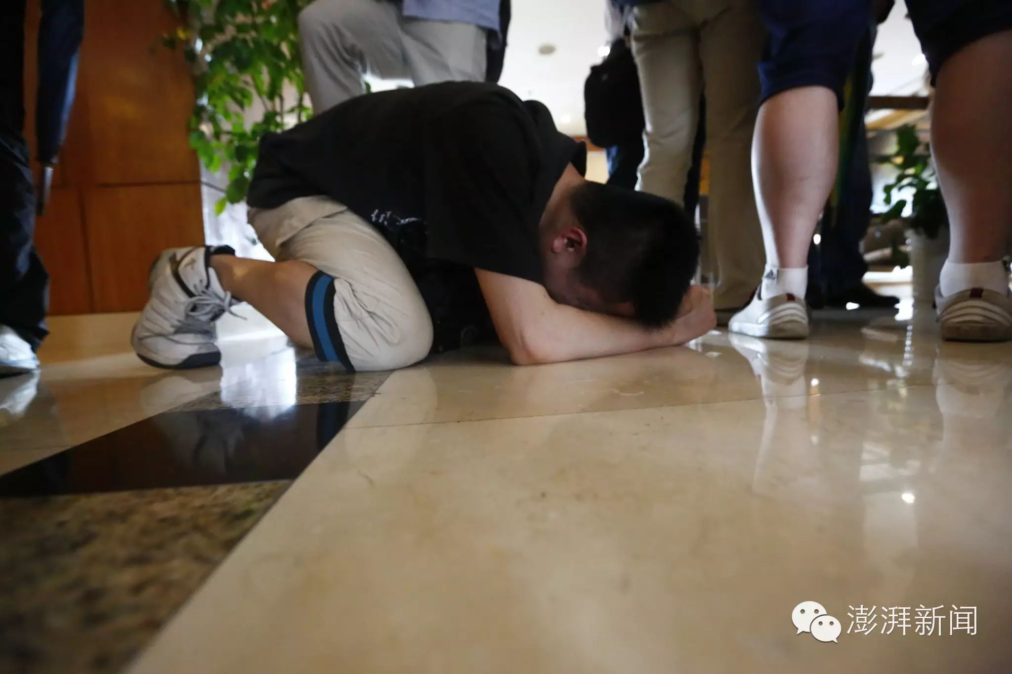 一名男子悲怆跪地,还有一名年轻男子蹲在门口哭喊:"爸妈我错了,我不