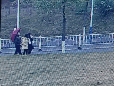 ▲&nbsp;从这段视频中我们看到，该男子撑着红色雨伞尾随一名女同学。