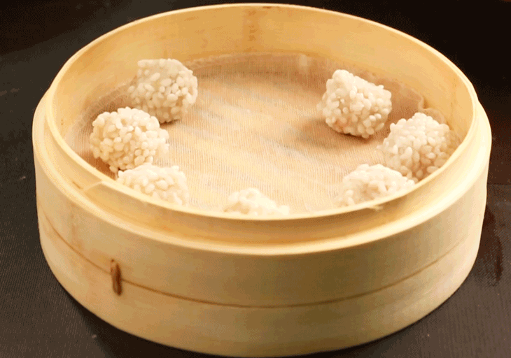 取一小团搓成球,盘子里铺上提前浸泡好且沥干水份的糯米,将搓好的丸子