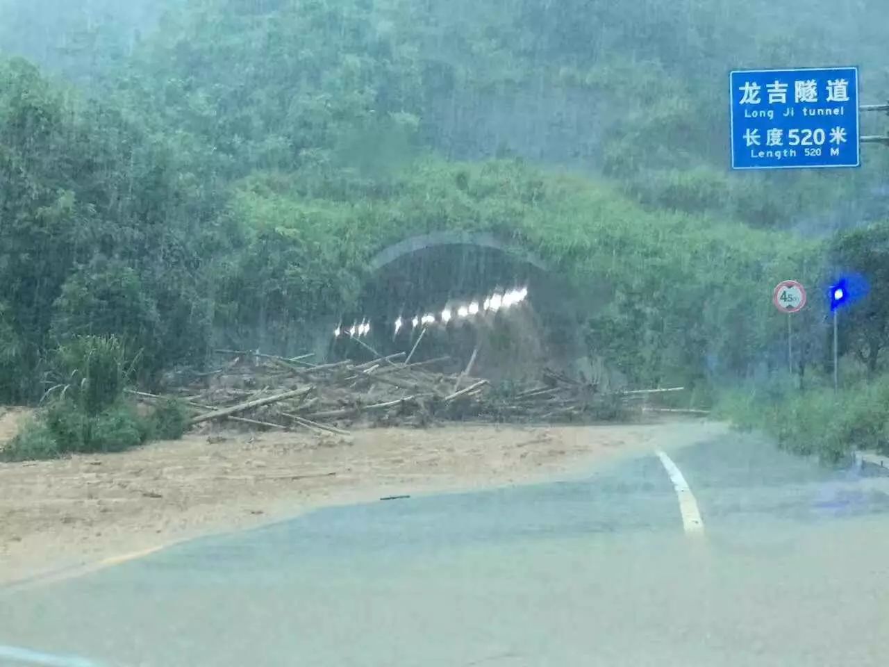 去往三江南站的龙吉遂道口有大量木头从山上冲下.