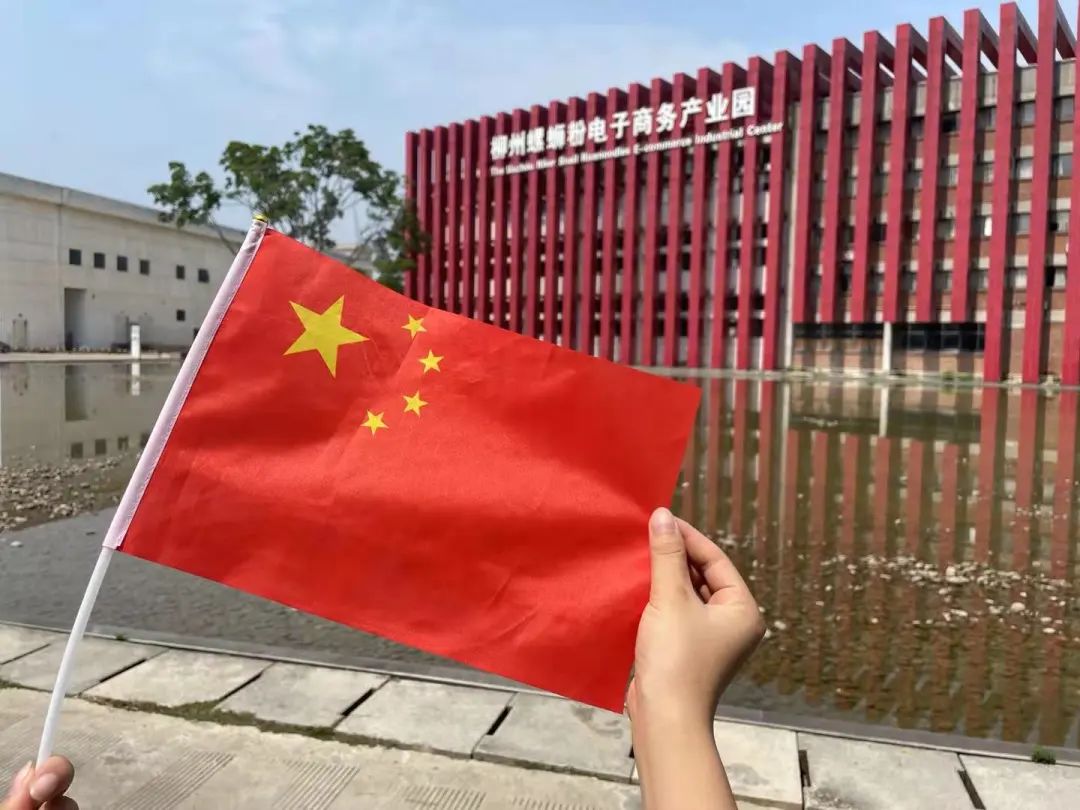 道路两侧的路灯杆上挂着五星红旗十月第一天的阳光轻柔洒落有一种表白