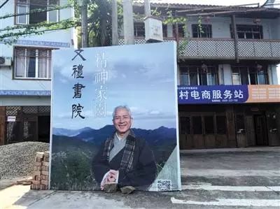文礼书院门前,王财贵的巨幅广告牌立在丁字路口。(《新京报》记者 罗婷 摄)
