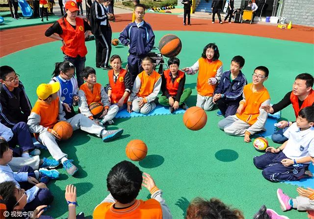 2015年4月2日,在浙江省宁波市北仑区阳光学校,志愿者和自闭症儿童一起玩游戏