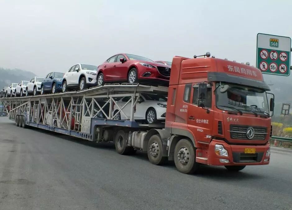 见到前方载着一车豪车的运输货车
