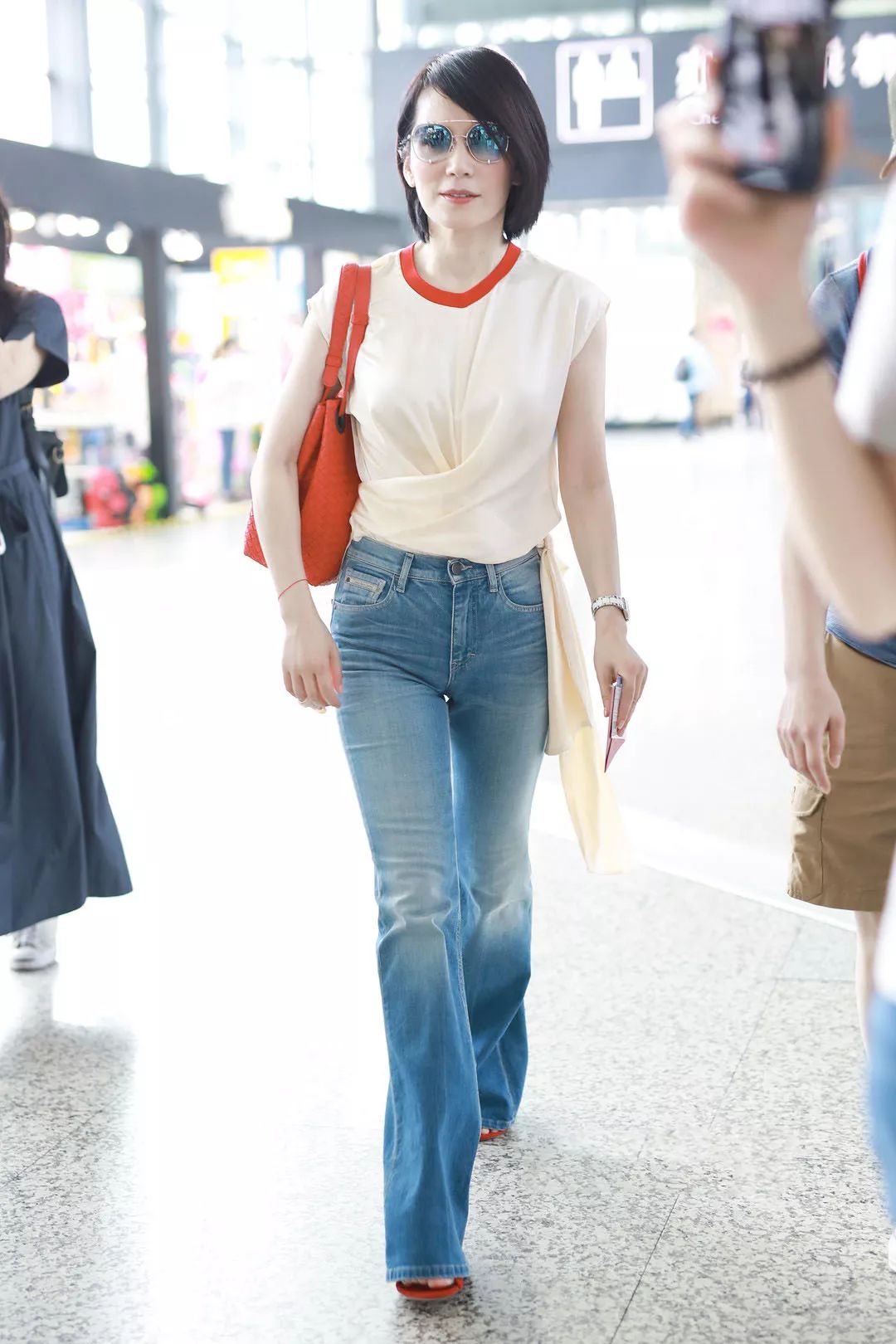 冻龄女神俞飞鸿身穿的这件绸缎t恤也非常时髦显白,搭配喇叭裤让她看