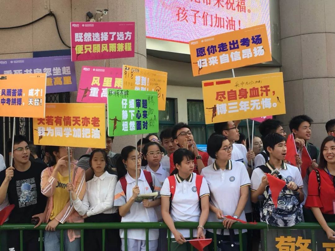 在 采荷中学考点,前来送考的保送生们手举标语牌,为同学加油打气