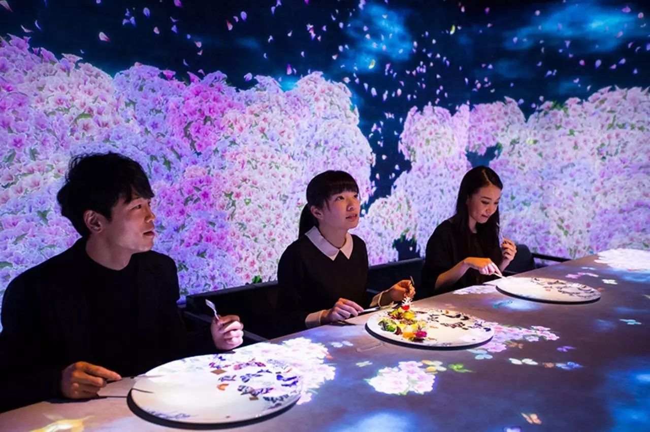 展馆中,他们可以在黑暗的房间中随性地探索。生长在国东半岛上的鲜花,会从一个个花骨朵开始,在地板与墙面上慢慢地盛开,当孩子们伸手触摸或从它们身边跑过时,一片片的花瓣会从花托上散开,樱花的粉色、油菜花的金黄色以及其他花朵的色彩将交错在一起,在一阵模拟流星滑落的哗啦啦乐声中,组成一幅无比绚丽的画面,最后回归黑暗并开启下一次盛开的过程。 未来游乐园是亲子玩乐互动的乐园。在teamLab Kids儿童艺术展区,艺术家鼓励孩子们用自己的手去创造一个独有的想象空间,而他们亲笔绘出的人物、动物、植物等图画将在