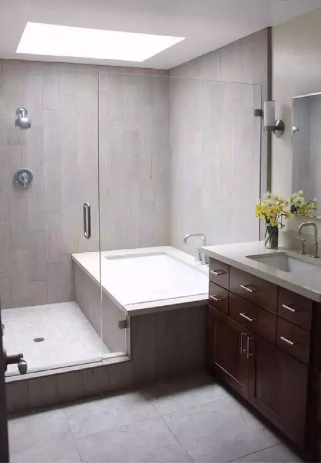 浴室里选择靠浴缸的一侧墙面,浴缸侧边和地面都采用水泥灰地砖,有着