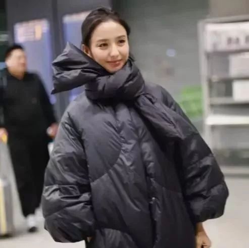 佟丽娅现身机场,网友:这件羽绒服外套必火!居然还能打个结?
