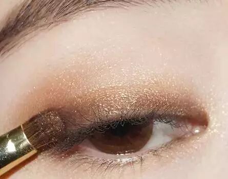 3.眼影刷沾取深棕色眼影晕染在眼睑上,接着在眼尾晕染出倒勾.