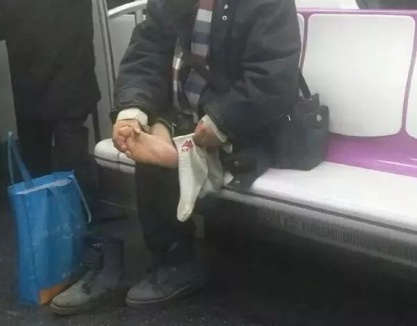 图为地铁15号线,大叔上车当众脱鞋脱袜后抠脚丫子.
