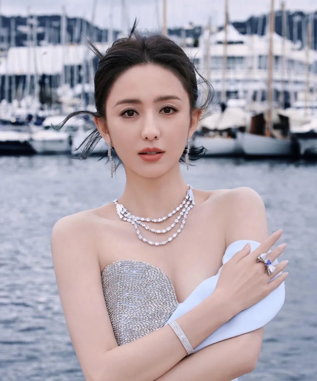 女性佩戴钻石珠宝，在港口前摆姿势