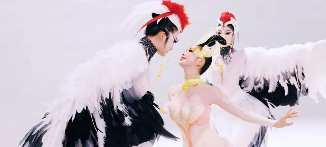 三位女性身着鸟类主题服饰，在明亮背景下摆姿势