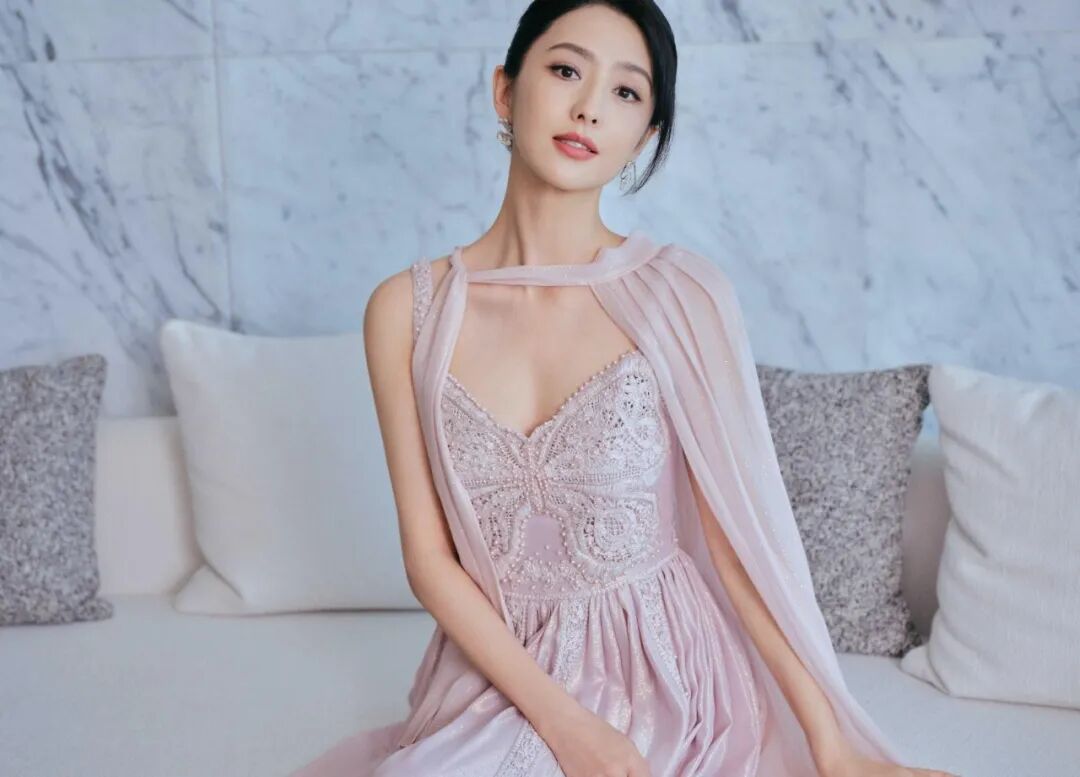 亚洲女性身着优雅浅粉色长裙摆姿势