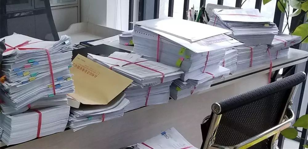 看这桌上堆得满满的文件,可见业务量不是一般的多啊!