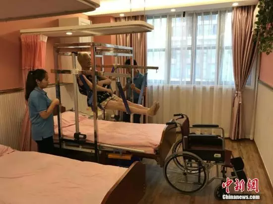 资料图:重庆一养老服务所自主设计的一款专为失能老人服务的“移动机”正式投用。只要开启设备,就能完成老人托举、移动等工作,减少了因护理不当给老人造成的二次伤害,减轻了老人的痛苦及护理人员的劳动强度。钟欣 摄