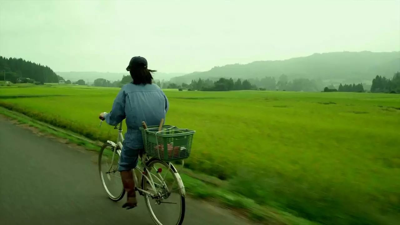 在这条空旷的村落里,女主角骑着自行车,行驶在回家的路上.