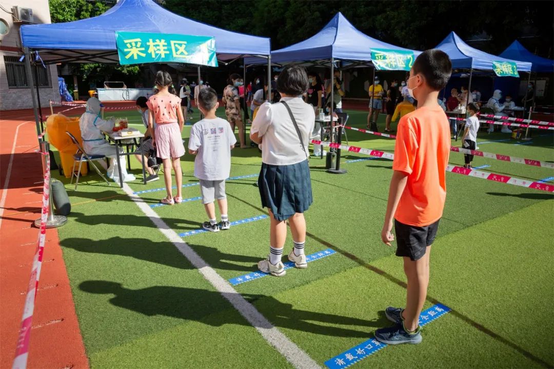 学生们乖乖地排好队等待进行核酸检测做好准备,高效采样滨东小学