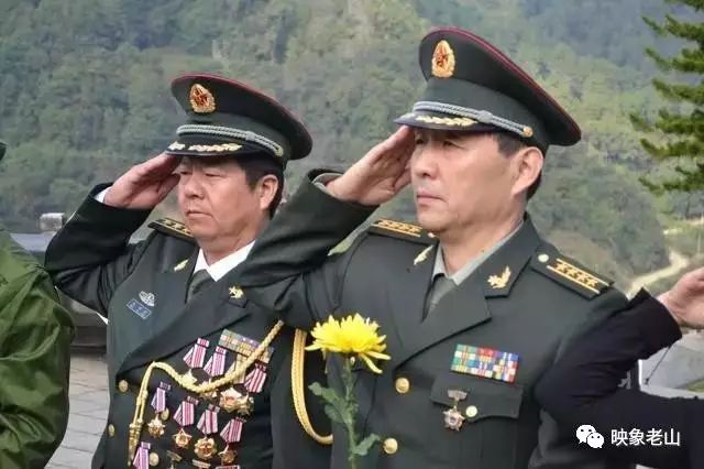胸前挂满军功章的毛羽亮(左)与陆军某部大校胡国桥在烈士陵园祭战友