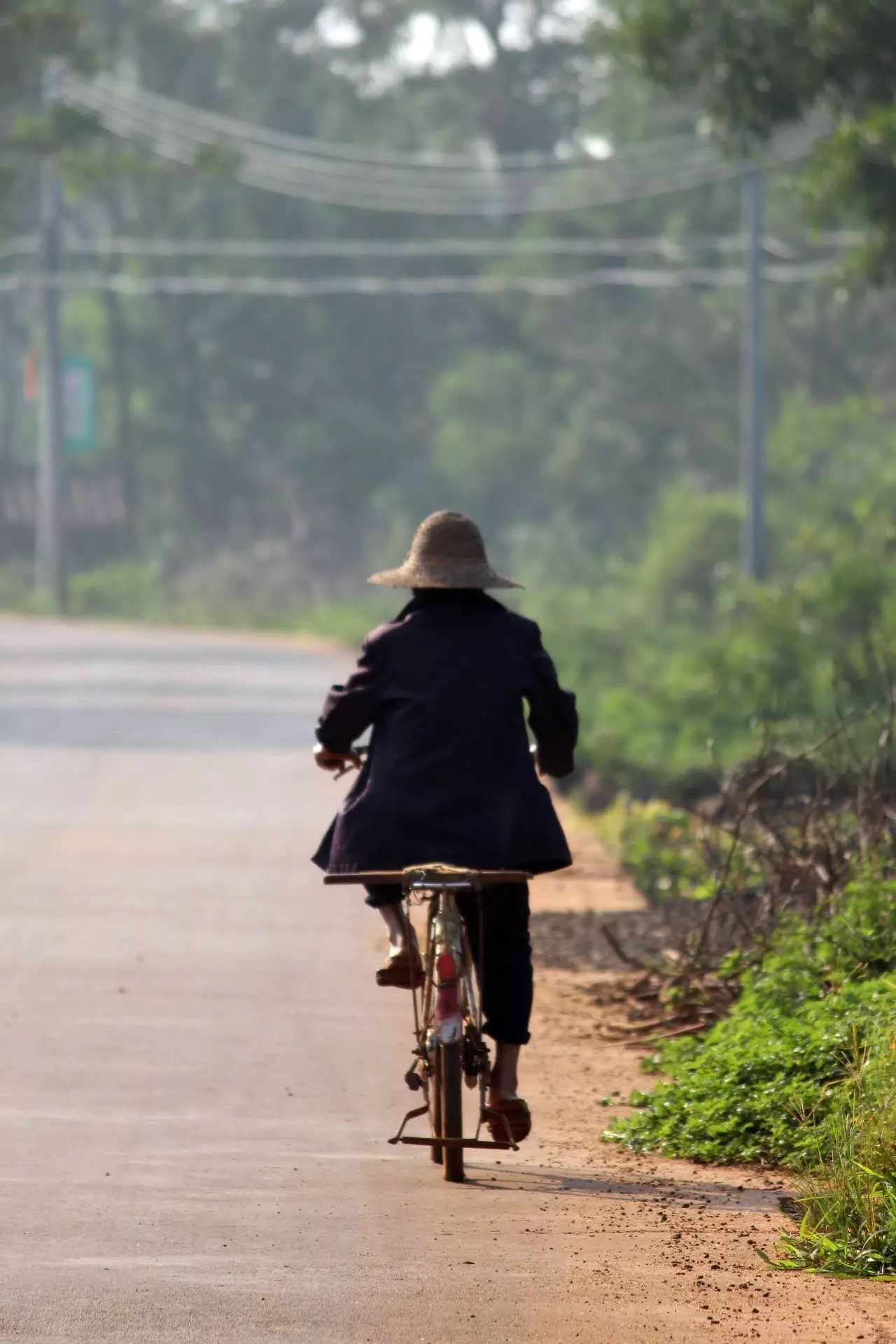 在通往小镇的公路上 经常看到这么一位老人 骑着旧自行车 车速缓慢 却