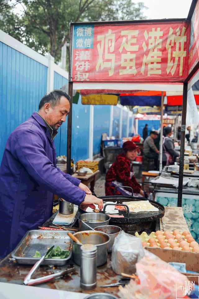几位阿姨身手麻利:油煎好的饼皮上刷满甜面酱,再铺上一层卤肉,夹入