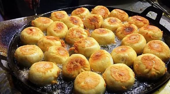 煎包四面都经过煎锅铸出的如黄金铠甲的脆壳,咬下去,粉红色鲜肉,经过