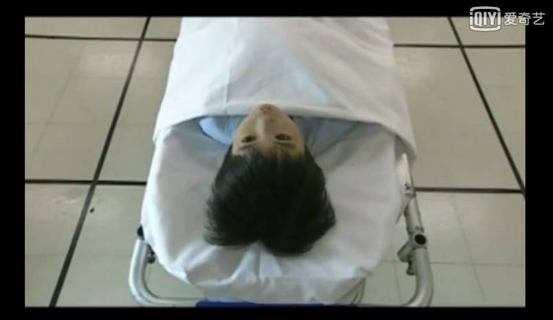 男主去捡遮脸布,这时候尸体躺着的推车突然剧烈抖动,小男孩突然动了.
