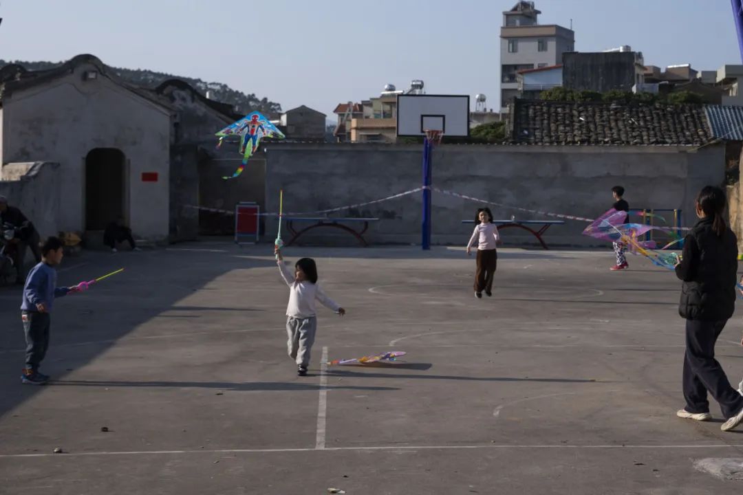 孩子们在绍业堂外的广场上放风筝。元宵节当天，人们就在这里迎接火龙出祠堂