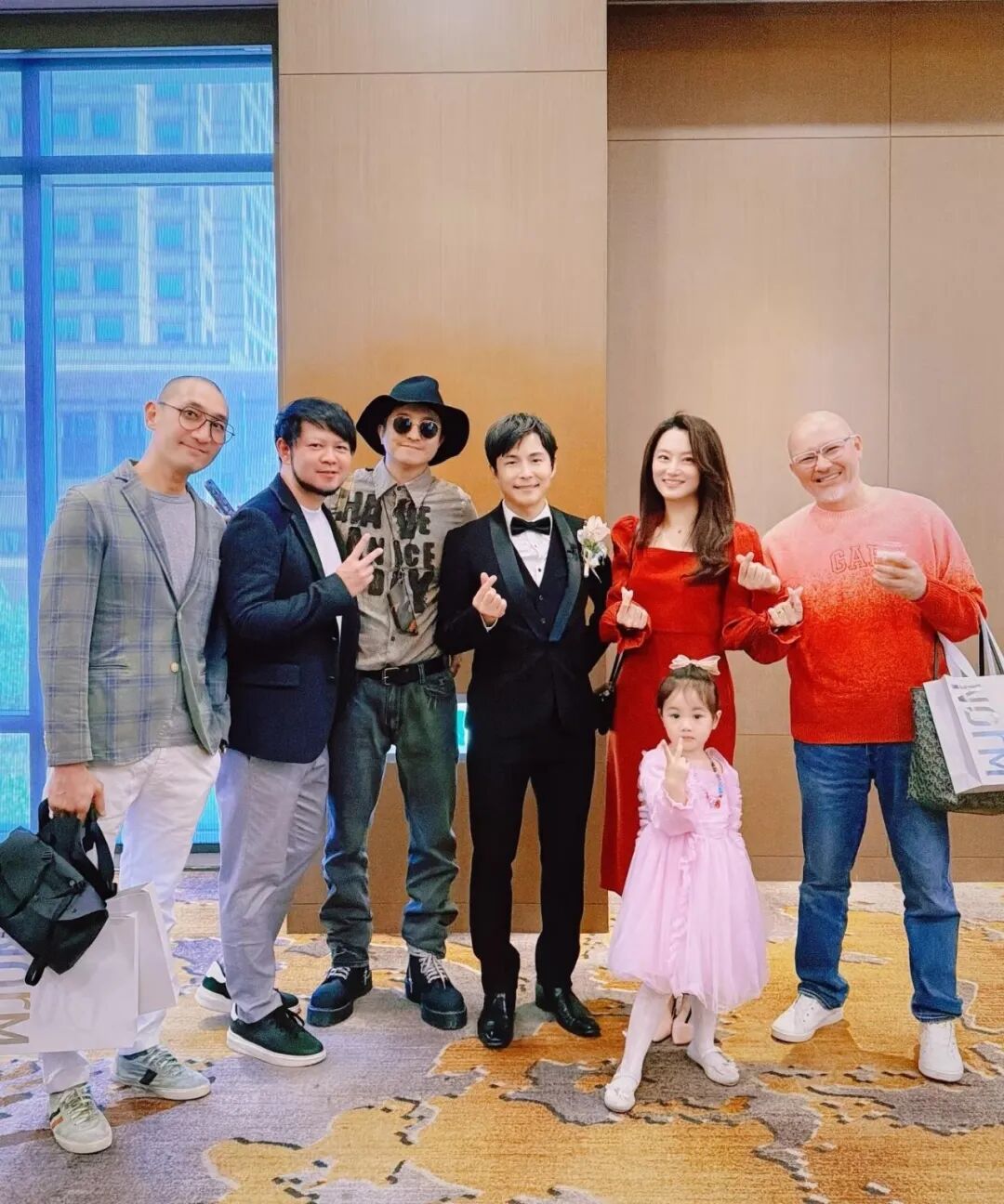A group of people, including a bride and groom, posing for a photo at a wedding