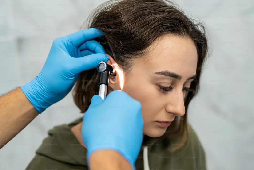 Advanced examination of a woman's ear using an otoscope at a doctor's appointment. Otoscopy. Visit to the ENT doctor and consultation