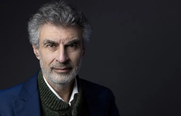 Portrait of Yoshua Bengio against a dark background.