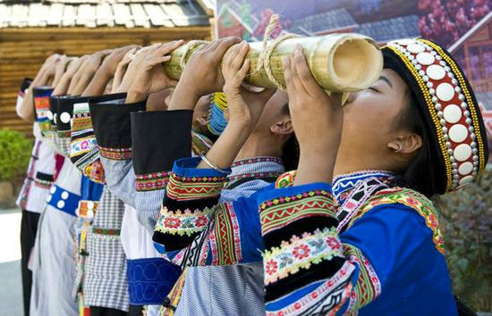 饮酒之一条心,美丽的傈僳族姑娘用竹筒串联起盛满米酒的竹筒酒杯,客人