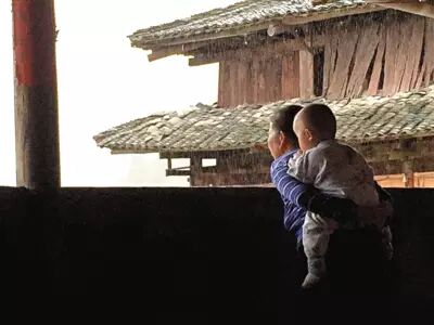 杨芋的奶奶背着小孙子在等他放学.杨芋被当地人认为是"再生人".