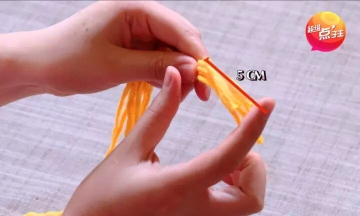 再次将每根毛线都穿过吸管,像下图这样把中间的绳子打结,让中间出现一