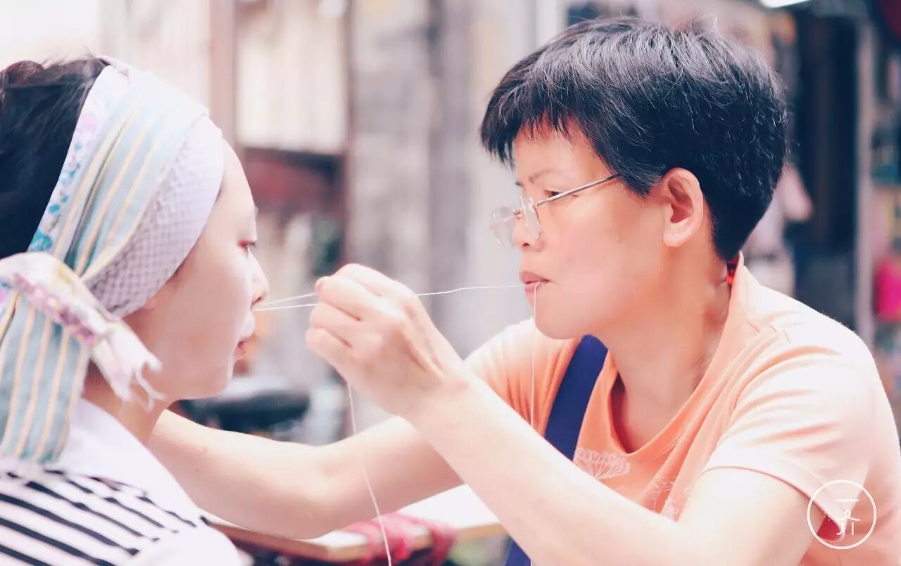 一盒粉,一根线对折,在指间绕上几匝,一端咬在口,一端握在手,过去,挽面