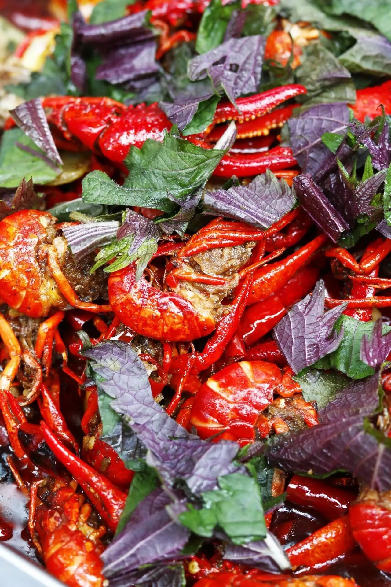 混合大蒜,葱,花椒等香料和秘制汤汁烹调而成,最后铺盖紫苏,让小龙虾吸