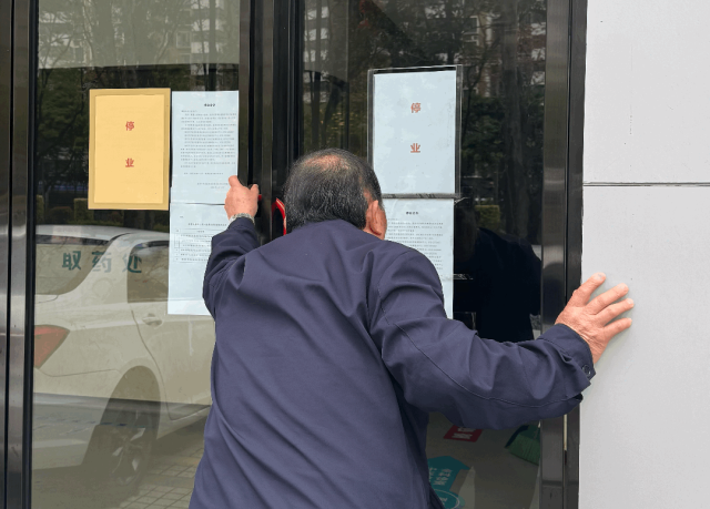 莲花社康中心门口，一名腿脚不便的老人在阅读停业通知。