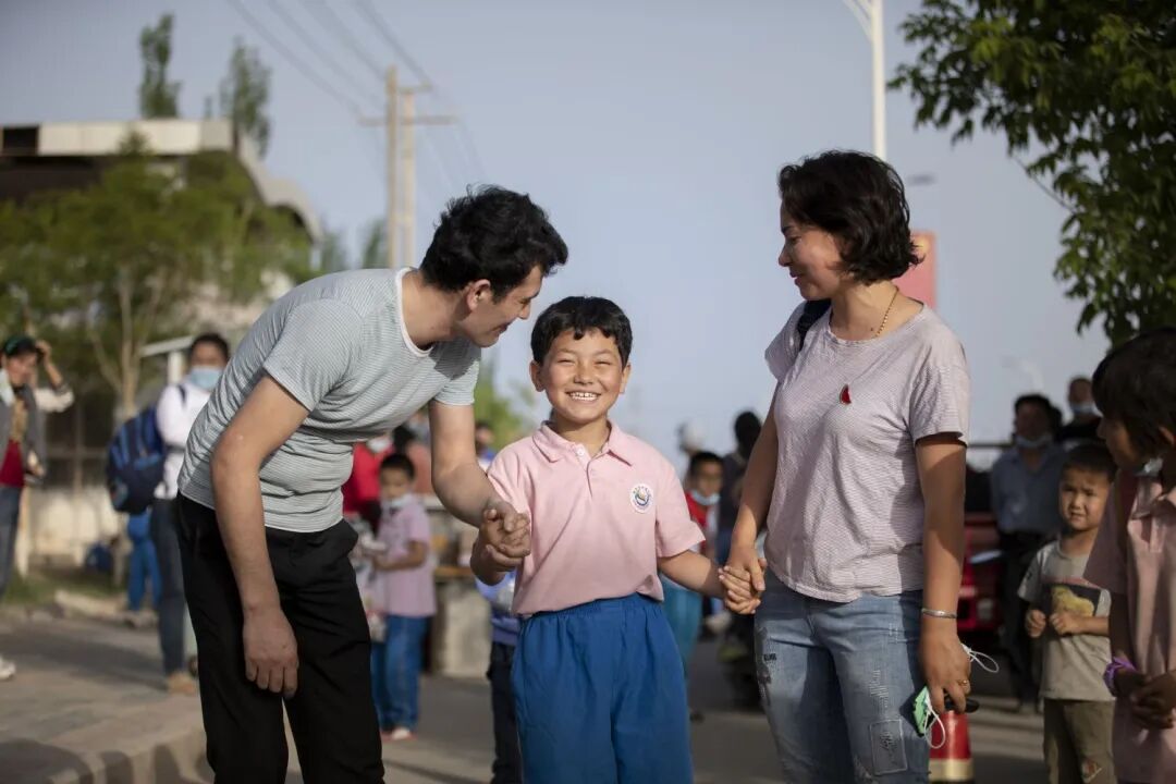 ▲艾山江·阿布都拉和妻子一起接女儿放学回家。
