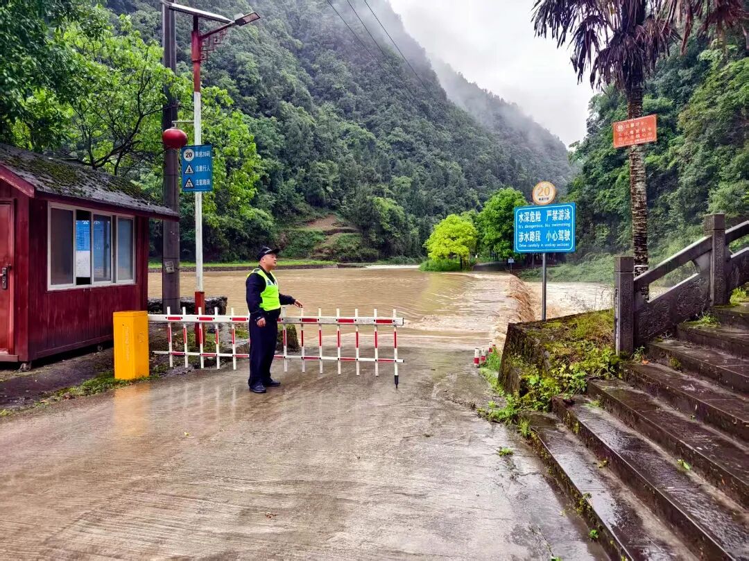 5.15绥阳县公安局枧坝派出所民警观察水位上涨情况并放下隔离栏杆.jpg