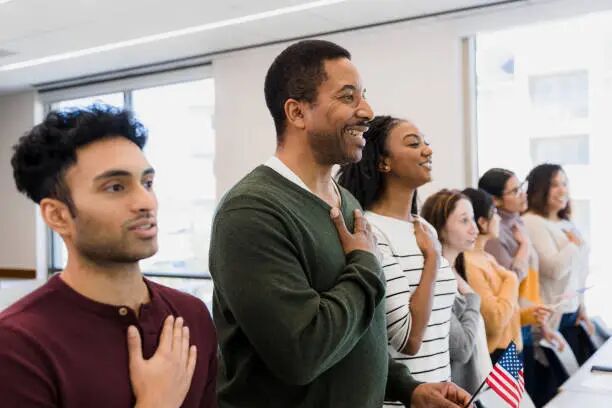 Class stands and recites The class stands to recite the Pledge of Allegiance with their hands on their hearts. us student visa stock pictures, royalty-free photos & images