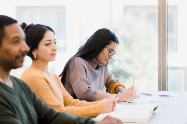 Classmates take notes during class The students take notes during class to study later. us student visa stock pictures, royalty-free photos & images