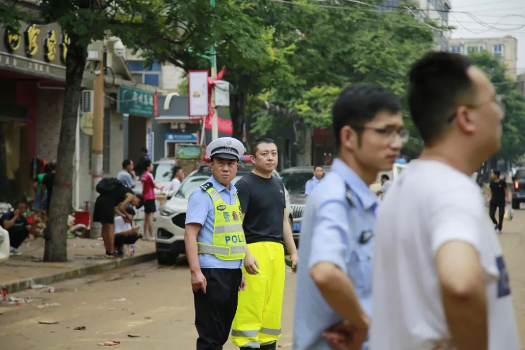 交警脱下雨衣裹住被困孩子抱进车内