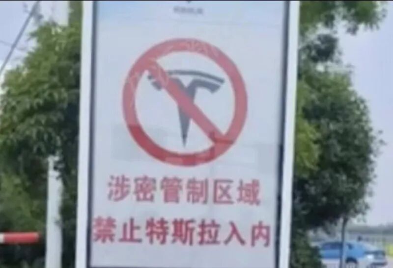 在岳阳三荷机场停车场，告示牌显示，“涉密管制区域禁止特斯拉入内”。